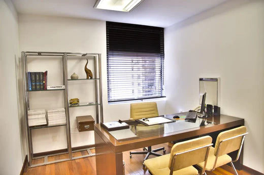 A small wooden executive desk in a compact office